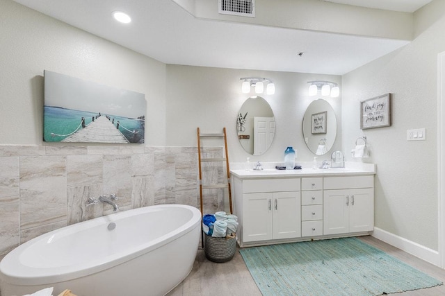 3404 American Dr Unit 3221, Lago Vista, TX 78645 - full bathroom with wood finished floors, double vanity, a freestanding bath, tile walls, and wainscoting