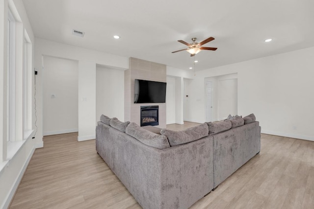 living area with recessed lighting, a fireplace, light wood finished floors, and ceiling fan