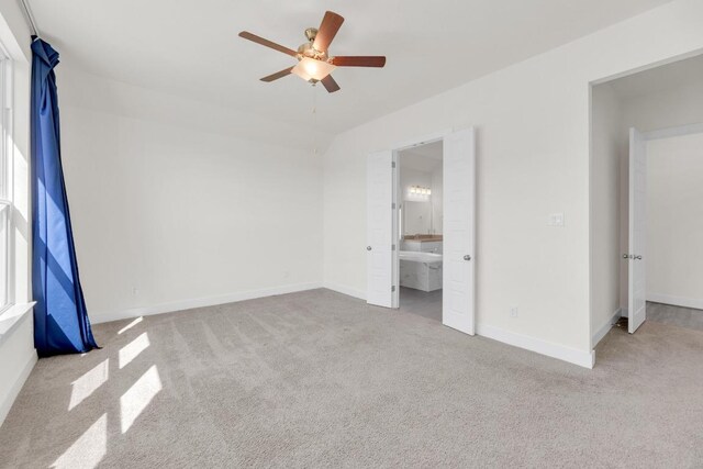 unfurnished bedroom with carpet, ensuite bath, a ceiling fan, and baseboards