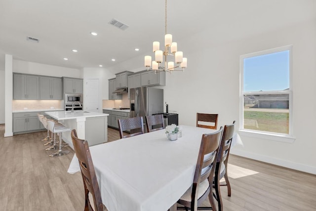 dining room with recessed lighting, visible vents, a chandelier, light wood-type flooring, and baseboards