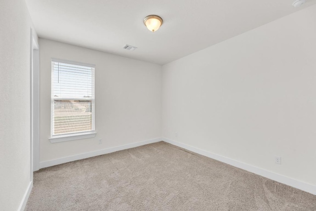 carpeted empty room featuring visible vents and baseboards