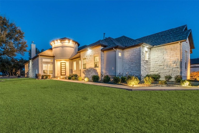 view of front of home featuring a front lawn, stone siding, and a chimney