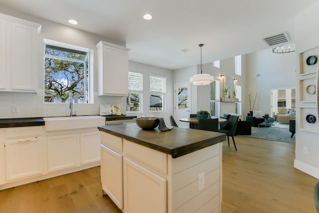 kitchen with recessed lighting, visible vents, backsplash, light wood-style floors, and a sink