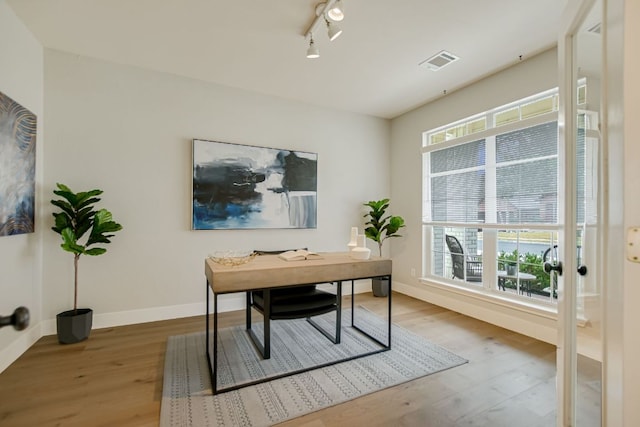 office with a wealth of natural light, visible vents, and wood finished floors