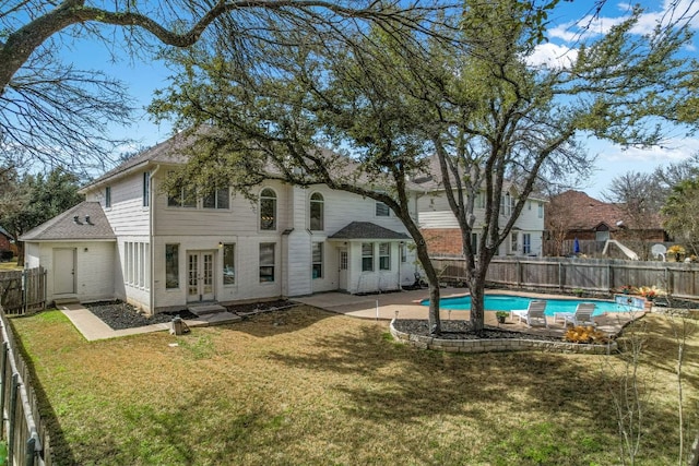 back of property featuring a fenced backyard, french doors, a lawn, a fenced in pool, and a patio area