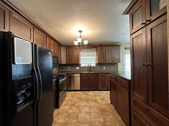 kitchen with a chandelier, stainless steel appliances, a sink, backsplash, and decorative light fixtures