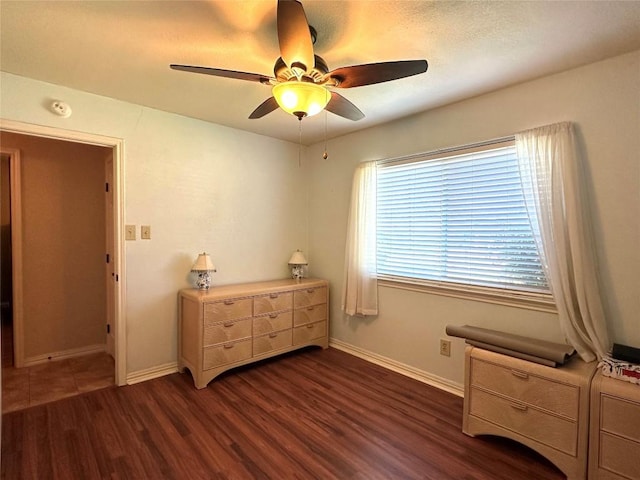 bedroom featuring ceiling fan, dark wood-style flooring, and baseboards