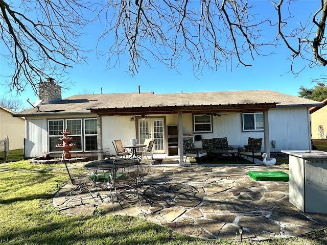 rear view of house featuring a ceiling fan, a patio, french doors, a chimney, and a yard