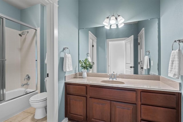 bathroom featuring toilet, shower / bath combination with glass door, tile patterned flooring, and vanity