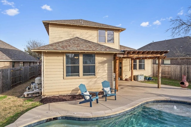 rear view of property featuring a fenced in pool, a fenced backyard, a patio, and a pergola