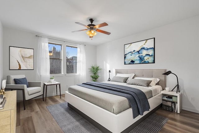 bedroom featuring wood finished floors, a ceiling fan, and baseboards