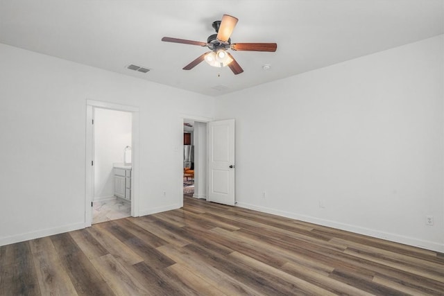 interior space with ceiling fan, wood finished floors, visible vents, and baseboards