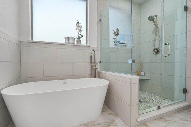 full bath featuring marble finish floor, a freestanding bath, and a stall shower