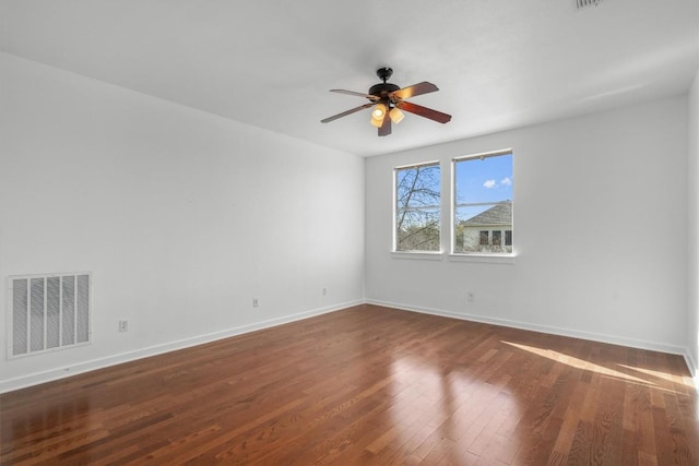 empty room with dark wood-type flooring, visible vents, baseboards, and a ceiling fan