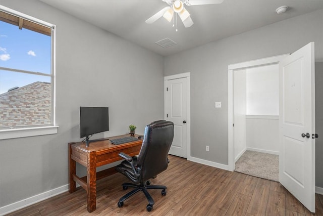 office area with wood finished floors, a ceiling fan, and baseboards