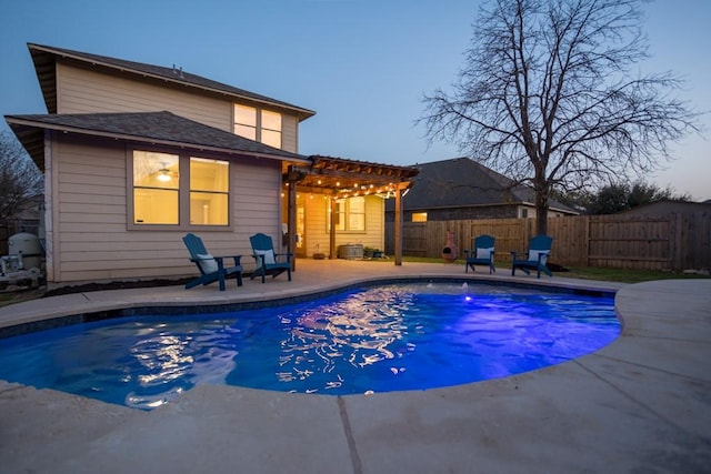 pool at dusk with a pergola, a patio, and a fenced backyard