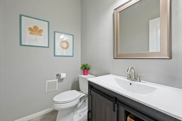 half bathroom with a textured wall, toilet, visible vents, vanity, and baseboards