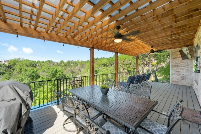 wooden deck with ceiling fan, area for grilling, and outdoor dining space