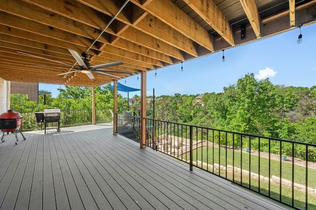 wooden terrace with ceiling fan and a lawn