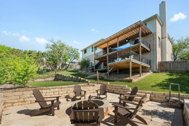 rear view of house featuring an outdoor fire pit, a chimney, fence, a yard, and a patio area