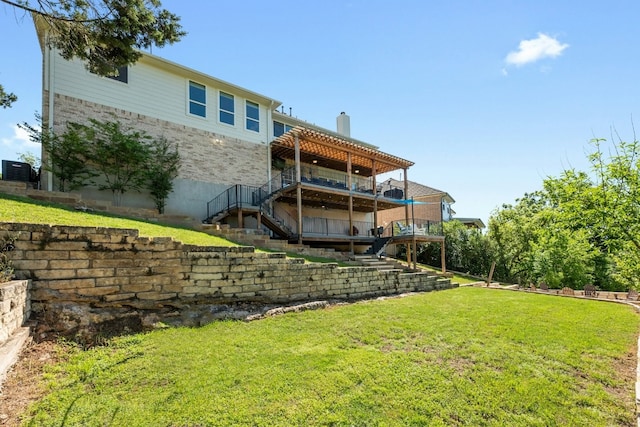 back of property with stairs, a yard, and a chimney