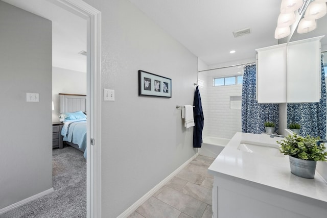 ensuite bathroom with visible vents, connected bathroom, vanity, and baseboards