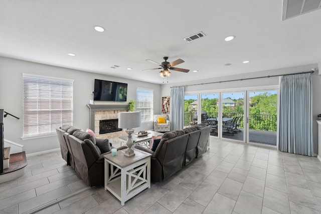 living area featuring a fireplace, visible vents, and a wealth of natural light