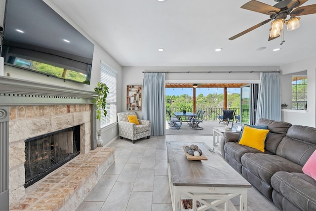 living area with plenty of natural light, baseboards, a fireplace with raised hearth, and recessed lighting