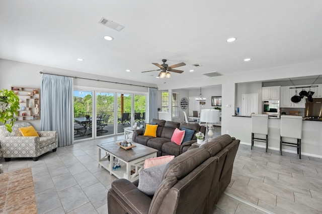 living area with recessed lighting, visible vents, and baseboards