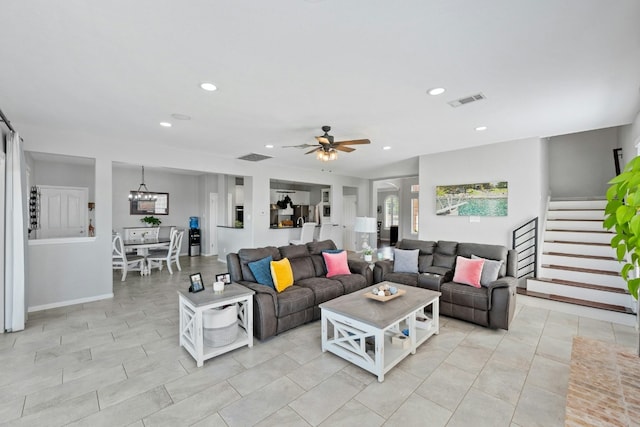 living area featuring ceiling fan with notable chandelier, stairway, visible vents, and recessed lighting