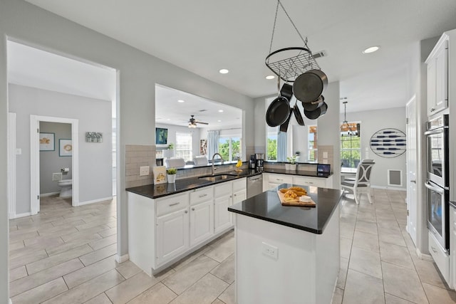 kitchen with stainless steel appliances, a fireplace, a sink, and a peninsula