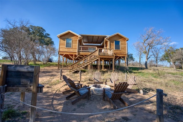 back of property with stairs, an outdoor fire pit, and a deck