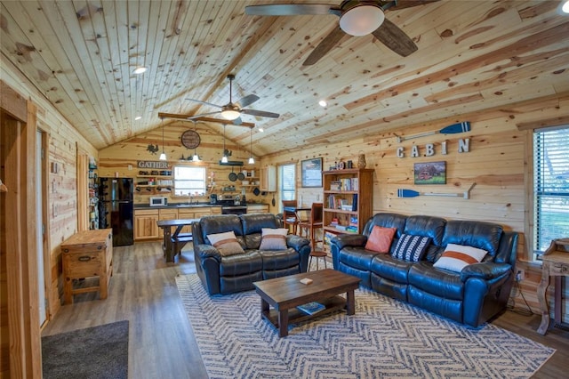 living room with lofted ceiling, light wood-style floors, wood walls, ceiling fan, and wooden ceiling