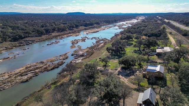 aerial view with a water view and a forest view