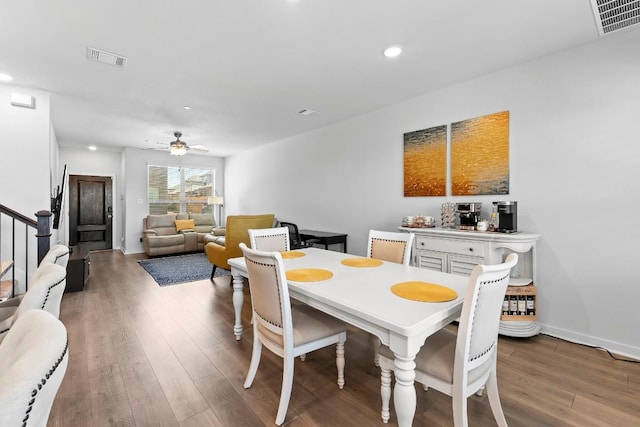 dining room with visible vents, stairs, and wood finished floors