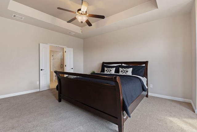 carpeted bedroom with a ceiling fan, a raised ceiling, visible vents, and baseboards