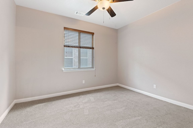 carpeted empty room with baseboards, ceiling fan, and visible vents