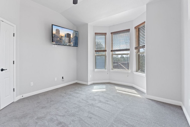 unfurnished room featuring lofted ceiling, ceiling fan, carpet, and baseboards