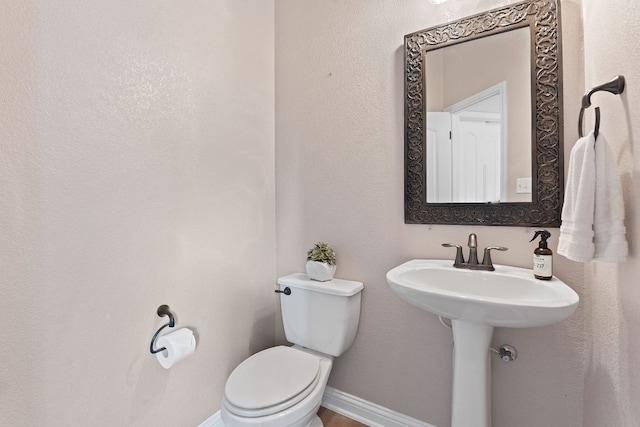 bathroom featuring toilet and baseboards