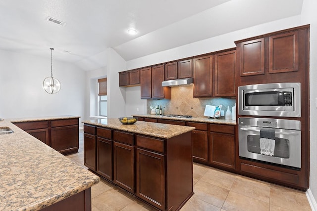 kitchen featuring visible vents, appliances with stainless steel finishes, hanging light fixtures, tasteful backsplash, and under cabinet range hood
