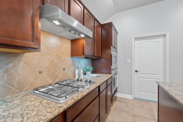 4801 Pyrenees Pass, Bee Cave, TX 78738 - kitchen featuring under cabinet range hood, stainless steel appliances, decorative backsplash, vaulted ceiling, and light stone countertops