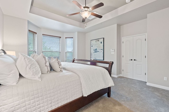 4801 Pyrenees Pass, Bee Cave, TX 78738 - carpeted bedroom with a raised ceiling, baseboards, a ceiling fan, and a closet