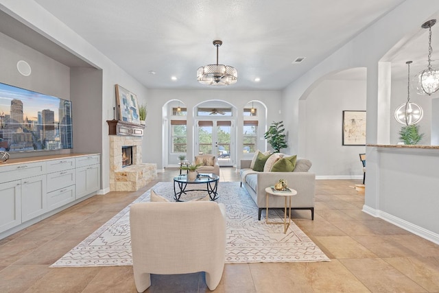 4801 Pyrenees Pass, Bee Cave, TX 78738 - living area featuring a chandelier, arched walkways, a fireplace, and recessed lighting