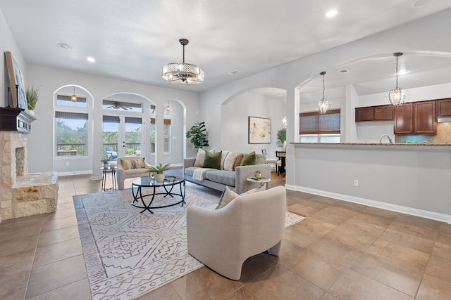 4801 Pyrenees Pass, Bee Cave, TX 78738 - living room with arched walkways, baseboards, recessed lighting, and a chandelier