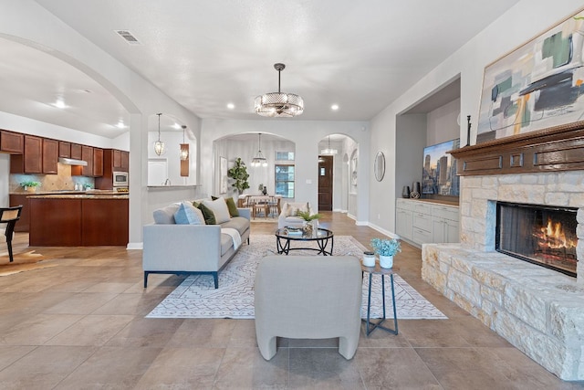 4801 Pyrenees Pass, Bee Cave, TX 78738 - living room with arched walkways, a chandelier, a fireplace, baseboards, and recessed lighting