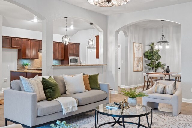 4801 Pyrenees Pass, Bee Cave, TX 78738 - living area with arched walkways, a chandelier, and baseboards
