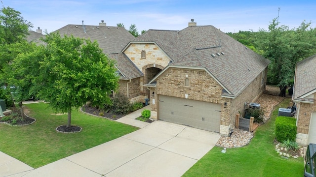 4801 Pyrenees Pass, Bee Cave, TX 78738 - french country inspired facade featuring concrete driveway, stone siding, a chimney, a front yard, and brick siding