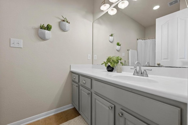 bathroom featuring tile patterned flooring, visible vents, vanity, and baseboards