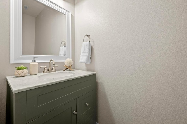 bathroom featuring a textured wall and vanity