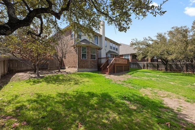 view of yard featuring a fenced backyard, a wooden deck, and stairs